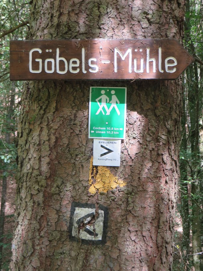Hier steht ein Bild mit dem Titel: Schon beim Abstieg von der Straße zum Bach weist das erste Schild auf Göbels Mühle hin. Es wied nicht das letzte Mal sein (Foto: Hans-Joachim Schneider)
