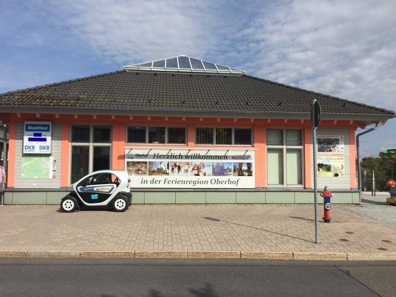 Haus, Gebäude der Touristen-Information von Oberhof, davor parkt ein Auto.